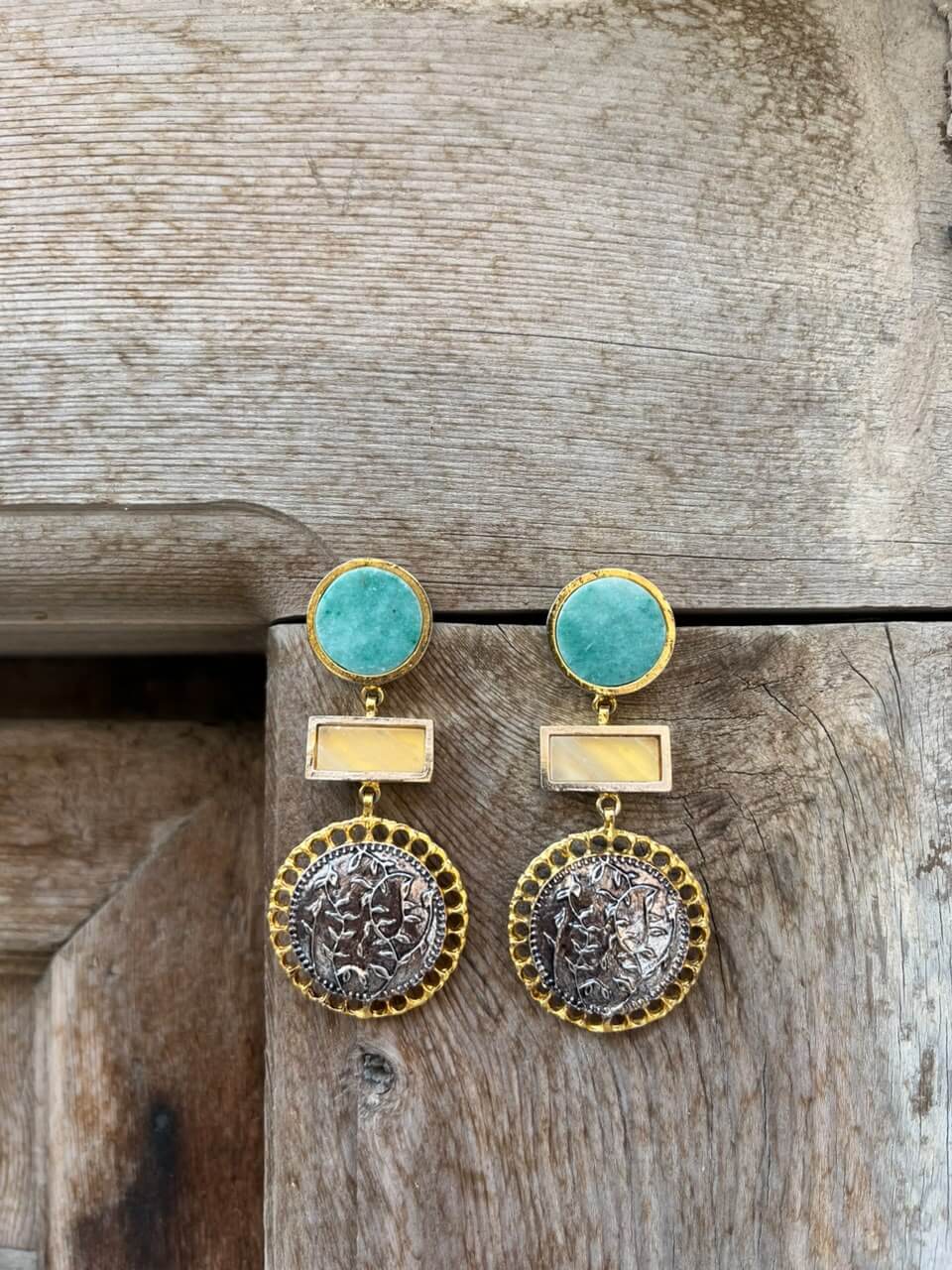 ROYA drop earrings with turquoise-blue round tops, yellow rectangular centres and dark engraved discs, displayed on wood.