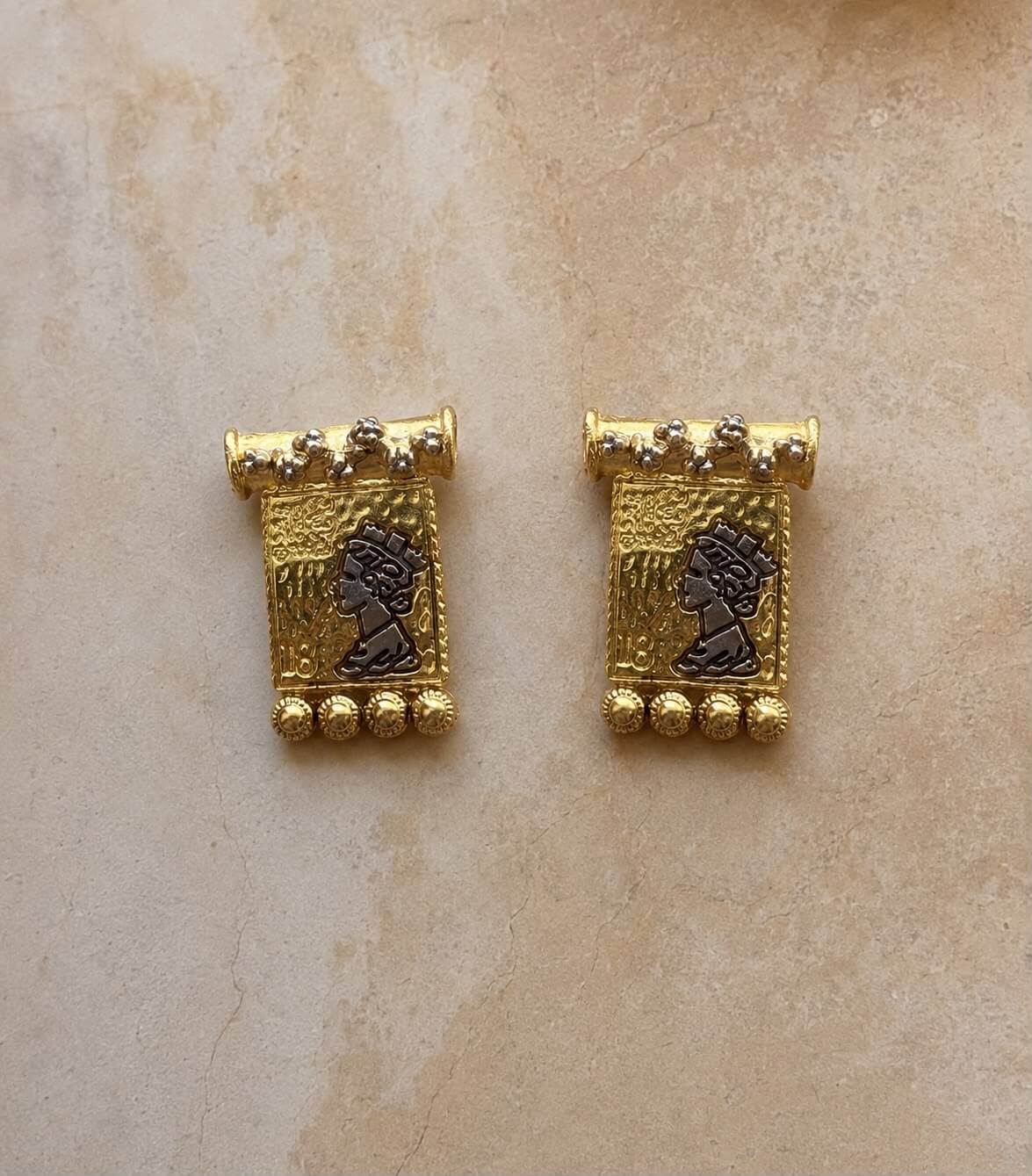 TALA gold-tone rectangular earrings with dark portrait motifs, floral studs and beaded edging on beige stone.