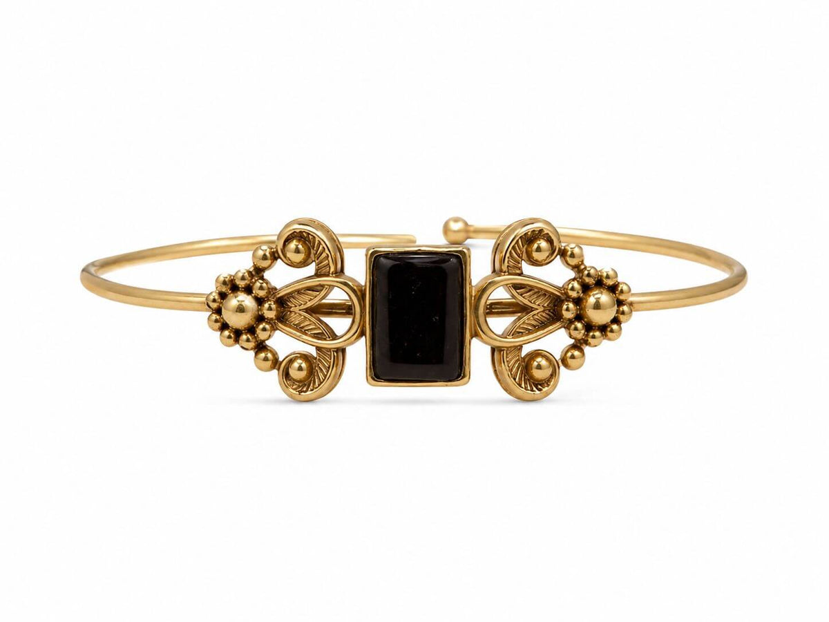 Victorian Churri bangle featuring a black rectangular centre, gold-tone scrollwork and floral motifs on a white background.